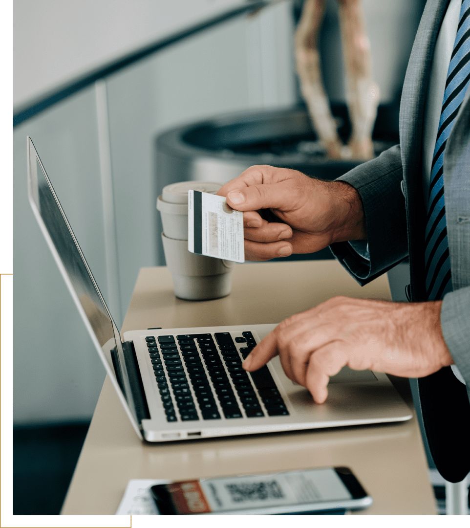 Person making an online payment with a credit card and laptop.