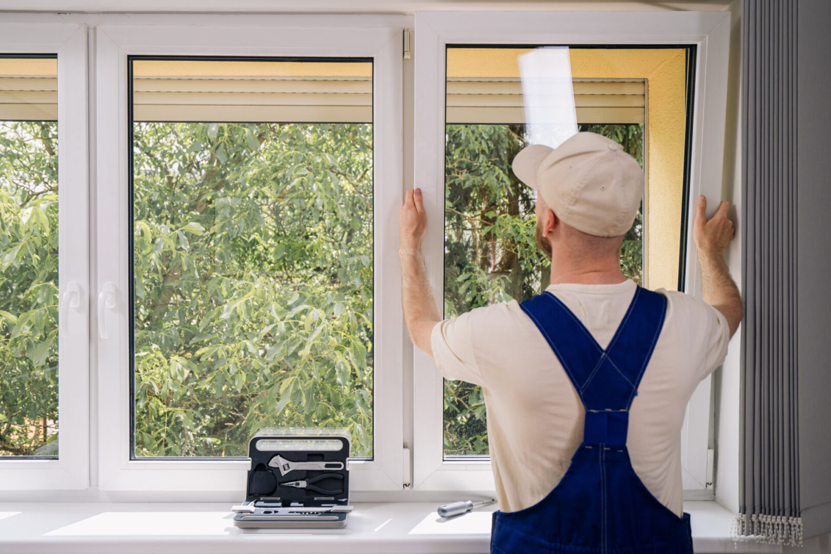 Worker installs a window frame in a house.